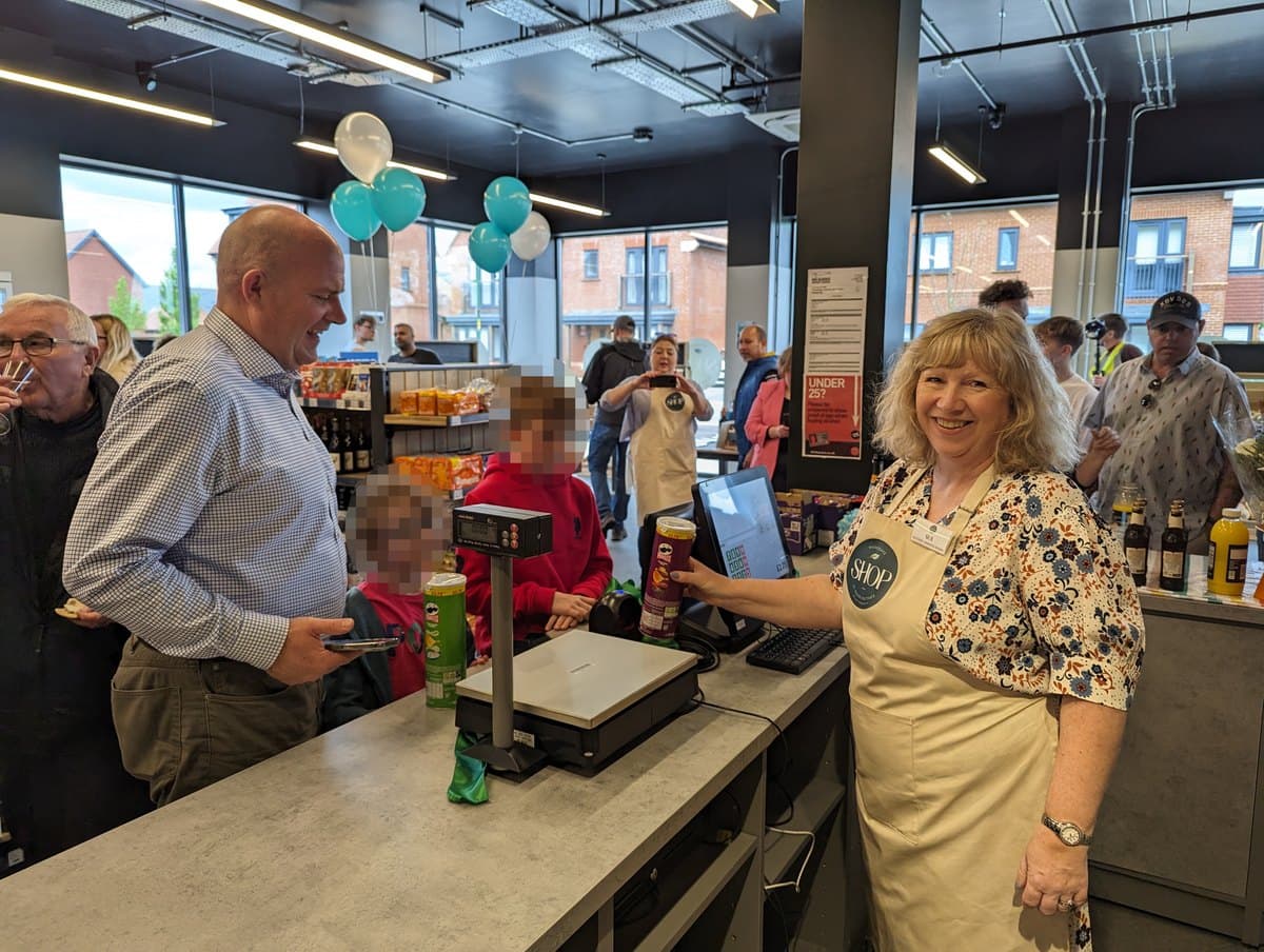 The first customer being served at Woodgate Community Shop on opening day